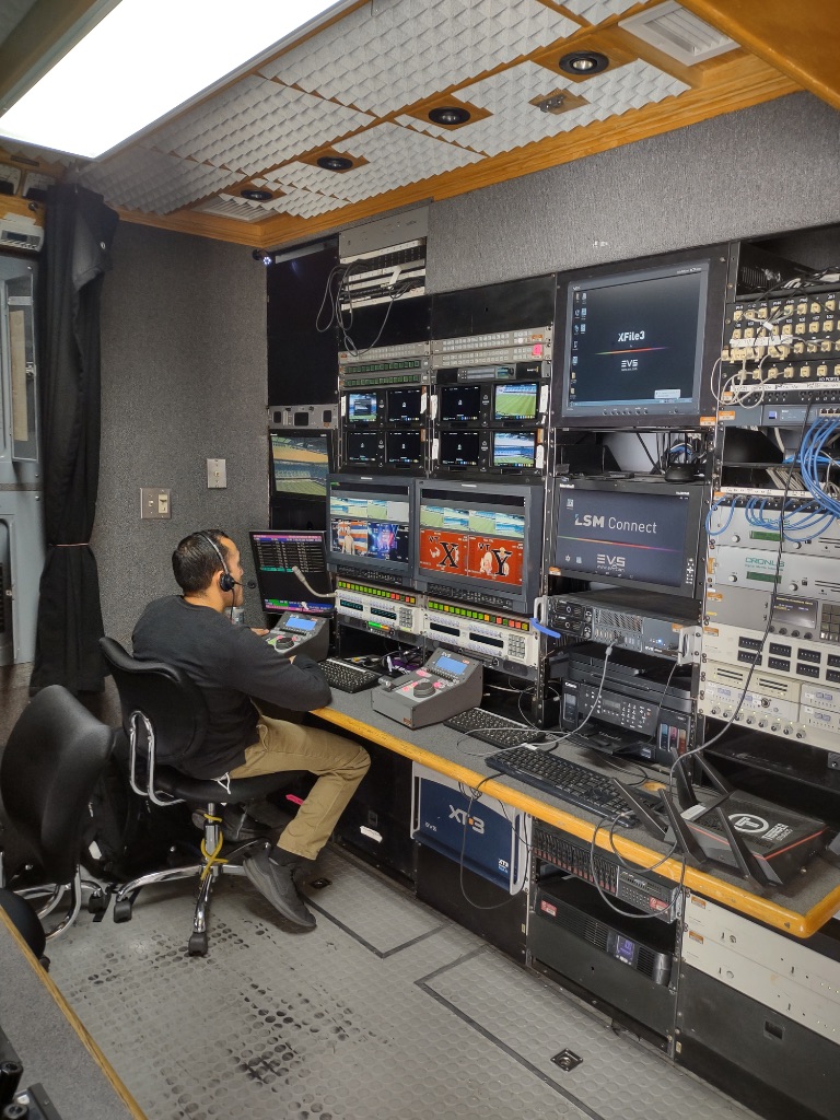 Broadcast engineer operating production systems inside mobile unit